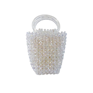 Détail d'un sac à main artisanal en perles irisées avec poignées anneaux en résine