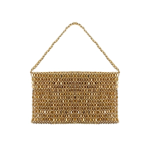 Detail of golden chainmail shoulder bag with shiny metal discs and woven texture