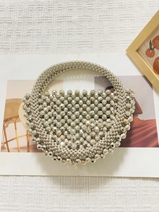 Dettaglio borsa a mano argento con perle artigianali e design a forma di mezzaluna