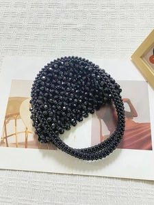 Dettaglio di borsa fatta a mano in perline nere sfaccettate con design a mezza luna elegante