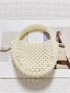 Dettaglio di perle bianche e tessitura di una borsa a mano artigianale a mezza luna