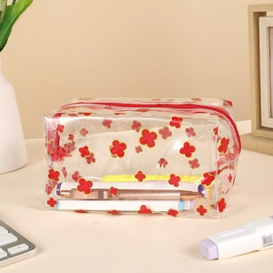 Detail of transparent PVC pencil case with red floral patterns and metal zipper closure