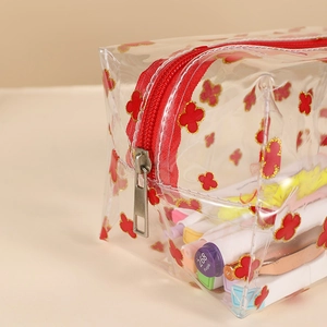 Detail of red zipper and floral clear PVC pouch showing large capacity for markers