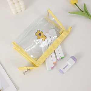 Close-up of a yellow PVC pencil case with cute bear prints on a clean desktop