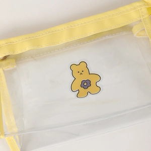 Detail view of transparent yellow PVC pencil case with reinforced stitching and bear print