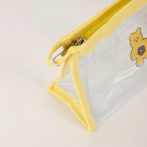 Detail of yellow zipper and leather trim on a transparent PVC cartoon bear pencil case