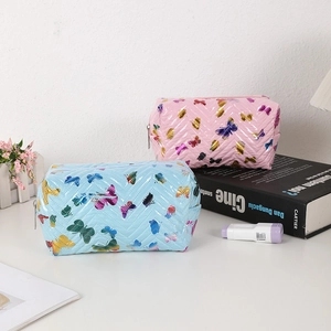 Detail of quilted butterfly makeup bags in blue and pink with glossy PU finish