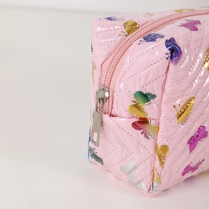 Close-up of pink waterproof makeup bag with colorful butterfly prints and silver zipper