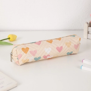 Detail of quilted beige PU pencil case with colorful heart patterns and metal zipper closure