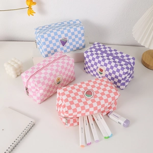 Detail of four colorful checkerboard canvas bags with cute fruit and flower embroidery