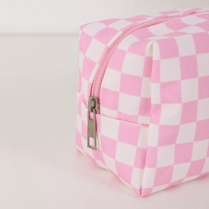 Detail of pink and white checkered makeup bag showing smooth metal zipper and fabric texture