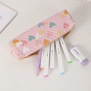 Detail of quilted pink pencil case with colorful heart patterns and gold metal zipper