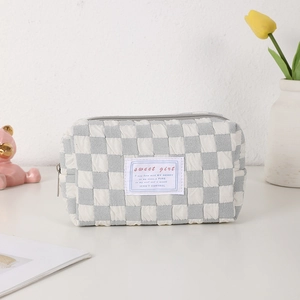 Detailed view of a quilted gray checkerboard pencil case with a sweet girl label