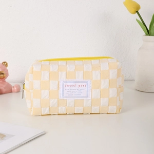 Detailed view of yellow checkerboard stationery pouch with Sweet Girl label and canvas texture