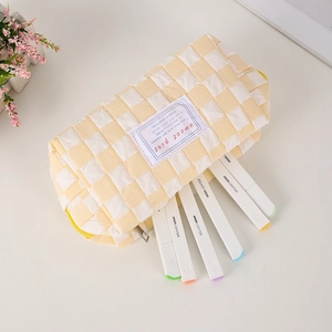 Close-up of yellow checkered pencil case with Sweet Girl patch and colorful markers