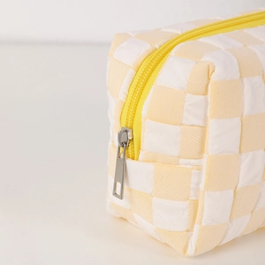 Detail of yellow checkerboard pencil case showing fabric texture and silver zipper