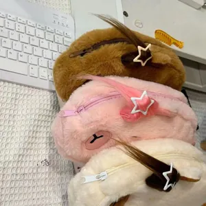 Macro shot of fluffy capybara pencil cases in brown, pink, and beige with star clips