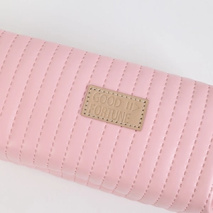 Close-up of pink quilted faux leather pencil case with GOOD II FORTUNE leather patch