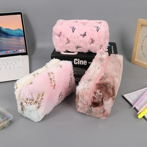Detailed plush pencil cases in pink and brown with zipper closure on a desk