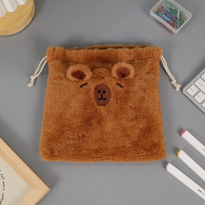 Vista dettagliata della borsa di peluche marrone con coulisse e ricamo di un orsetto