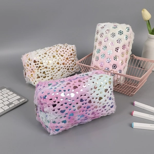 Macro detail of plush pencil cases with heart and snowflake foil patterns and zipper