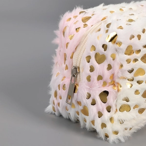 Macro view of pink gradient plush pencil case with gold heart pattern and metal zipper