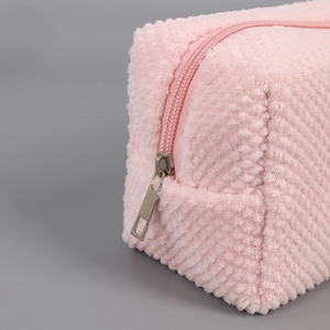 Close-up of soft pink plush pencil case fabric texture and silver metal zipper detail