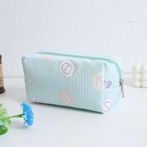 Detail of mint green corduroy gummy bear cosmetic bag showing soft ribbed fabric texture