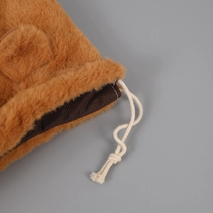 Dettaglio del morbido peluche marrone e della chiusura con coulisse in cotone bianco