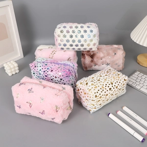 Detail of plush stationery pouches featuring snowflake patterns and soft faux fur texture