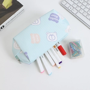 Macro view of blue striped gummy bear pencil case with stationery on a desk