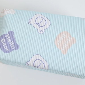 Close-up of light blue vertical ribbed fabric with Hello Bear cartoon patterns