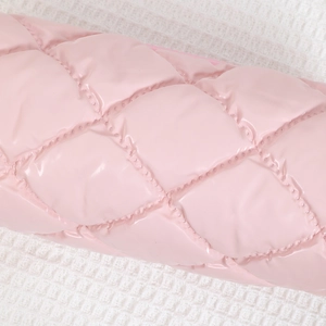 Detail eines rosa Federmäppchens mit glänzendem Rautenmuster und weicher Polsterung