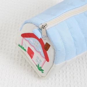 Detail of house embroidery and quilted texture on light blue multifunctional pencil case
