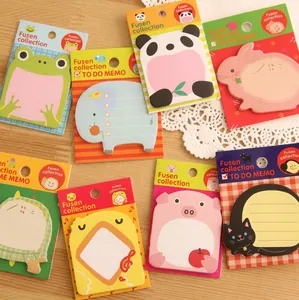 Close-up of cute animal-shaped memo pads in original packaging on a wooden surface