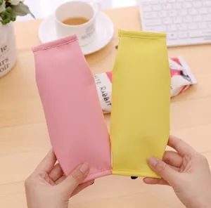 Detail of creative milk carton and popcorn shaped pencil cases held in hand