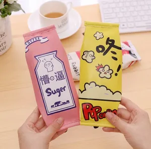 Detail of creative milk carton and popcorn shaped pencil cases held in hand