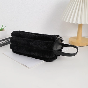 Detail of soft black faux fur pencil case with leather handle and smooth metal zipper