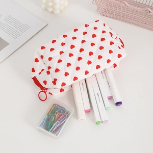 Detailed view of quilted cotton heart print pouch filled with various stationery and pens