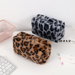 Detail of plush leopard print pouches with zip closure in brown and grey faux fur