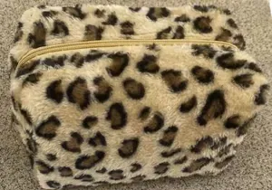 Close-up of leopard print plush makeup bag with gold zipper and soft faux fur texture