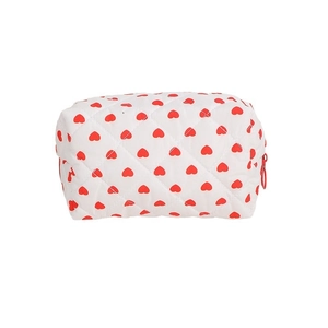 Quilted white cotton toiletry bag featuring red heart patterns and a zipper closure
