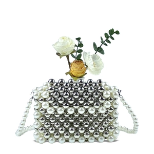 Detail of handmade beaded crossbody bag with silver beads and white pearls and roses