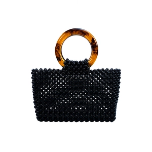 Vue détaillée du sac à main perlé noir fait main avec des poignées en résine ambrée