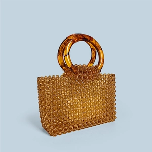 Détail d'un sac à main en perles ambrées avec doubles poignées en acrylique tortue