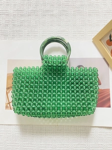 Détail du sac à main vert perlé à la main avec poignées en acrylique et perles claires