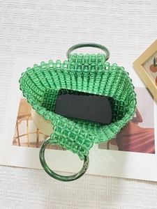 Détail du sac à main vert perlé montrant les doubles poignées et l'espace intérieur