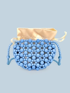 Dettaglio mini borsa di perline blu con fodera in raso dorato e chiusura a coulisse