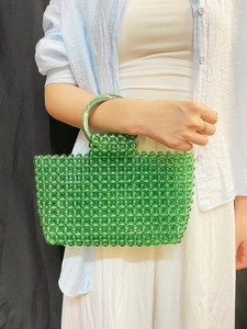 Gros plan détaillé d'un sac à main tissé en perles vertes avec poignée ronde en acrylique