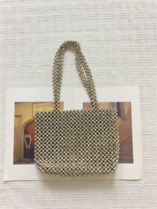Sac à main élégant perlé argenté avec finition métallique sur tissu gaufré blanc